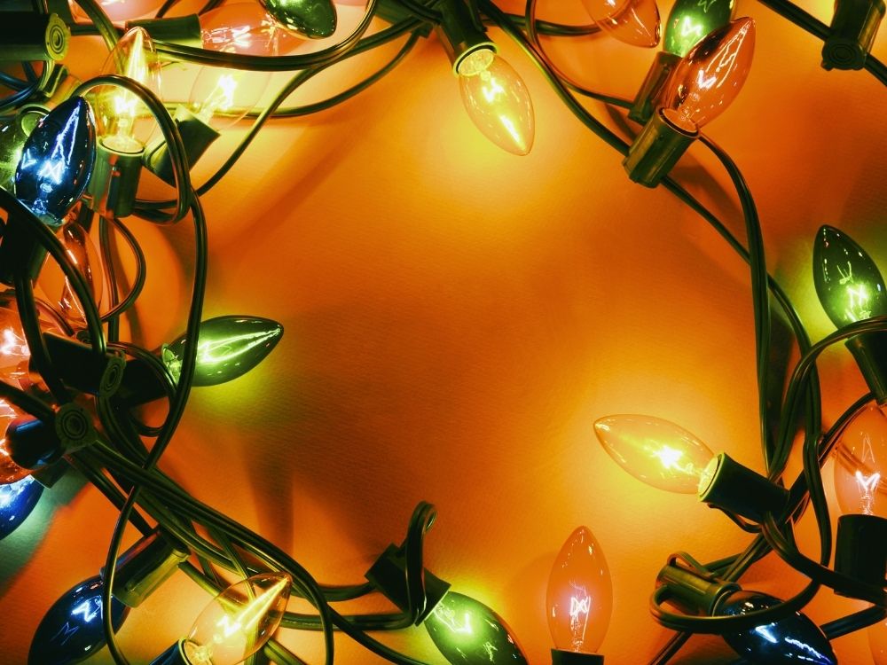 A red background with a sting of lit up Christmas lights bordered all sides.