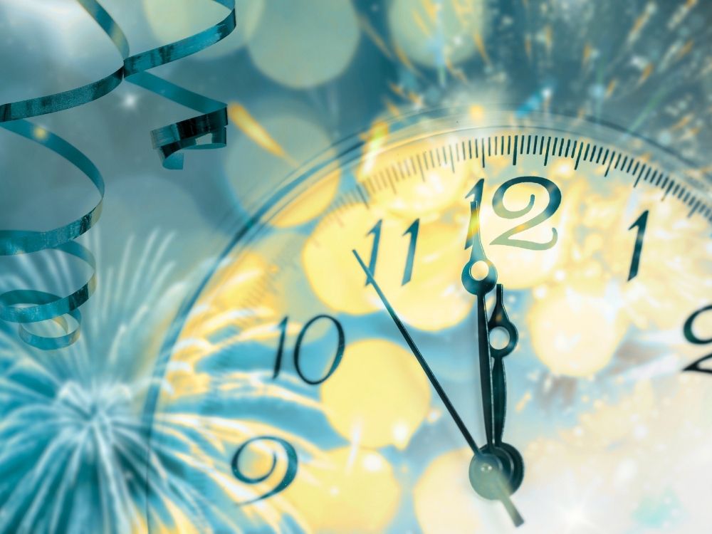 A clock and streamers representing the start of a new year.