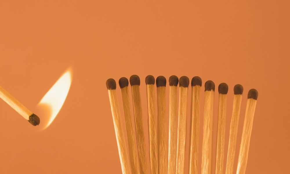 A flame set to light a spread of matches signifying the symptoms associated with toxic stress and trauma.