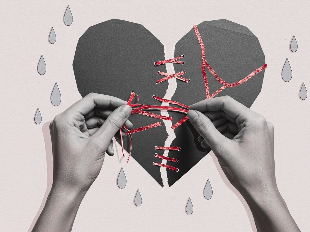 A set of hands stitching together a broken heart representing the painful reasons to choose recovery from toxic stress and trauma.