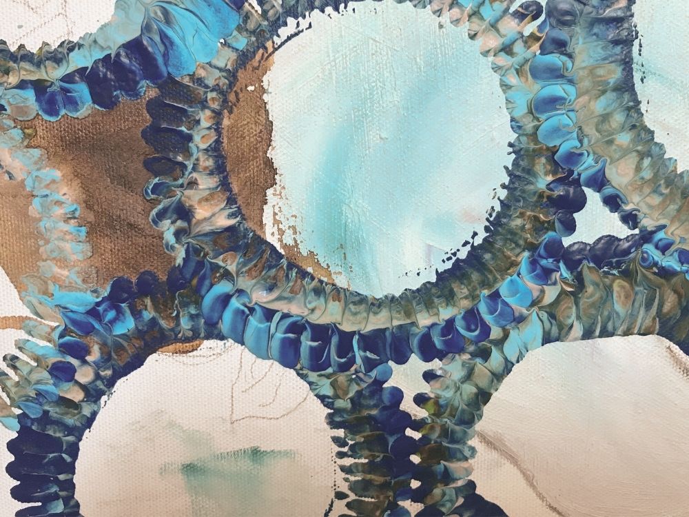 An abstract acrylic painting of edgy overlapping circles in blues and whites.
